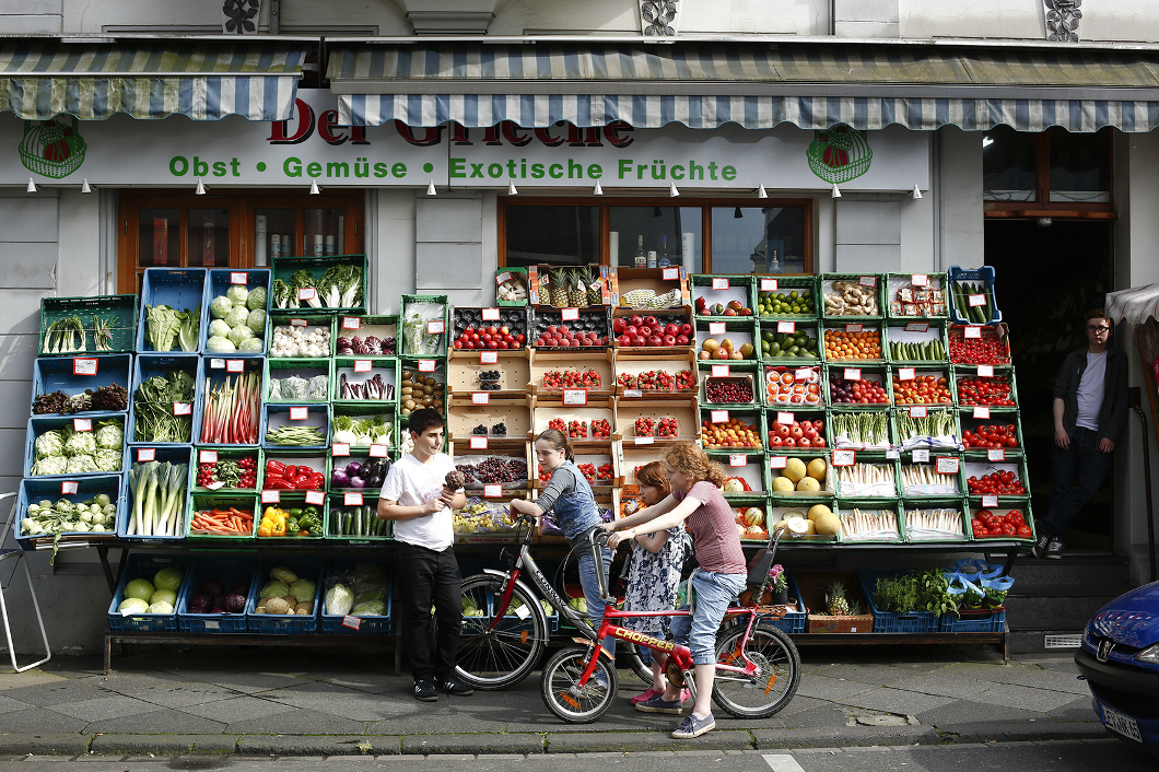 Ein Gemüseladen und Fahrrad fahrende Kinder